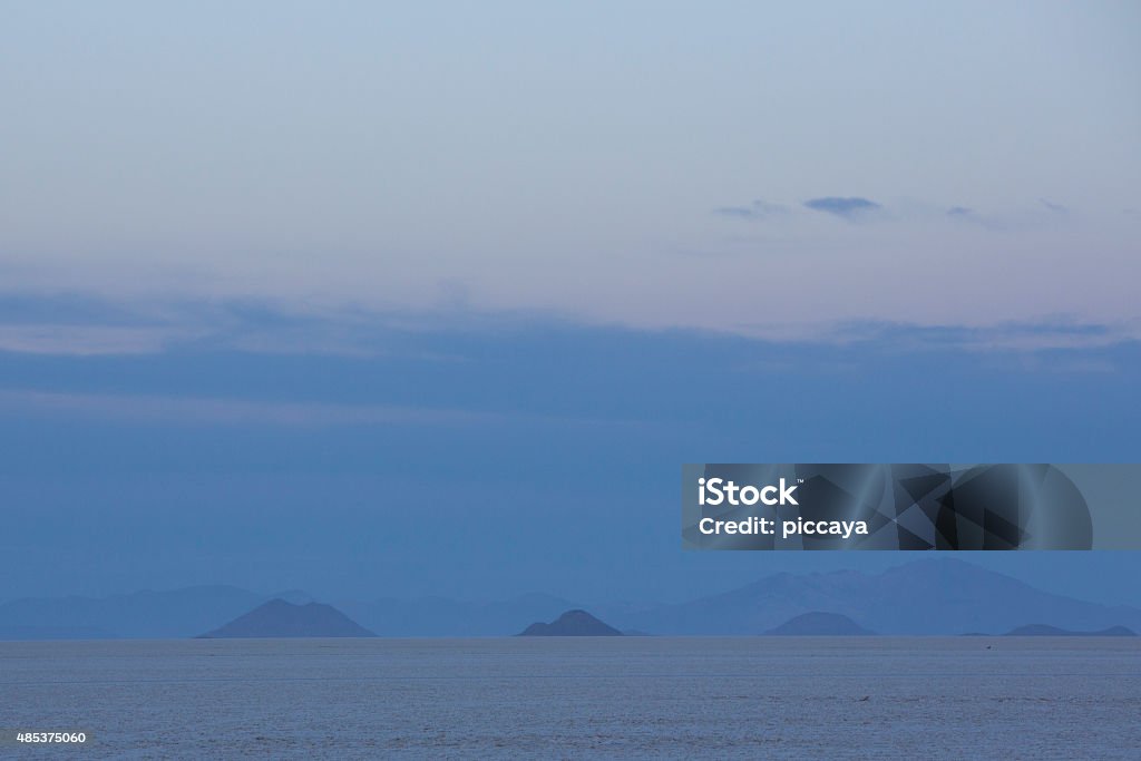 Panorama of the Salar of Uyuni with blue sky, Bolivia View of the Salar of Uyuni early in the morning during the dry season, the salt plains are a completely flat expanse of dry salt. Bolivia 2015 Stock Photo