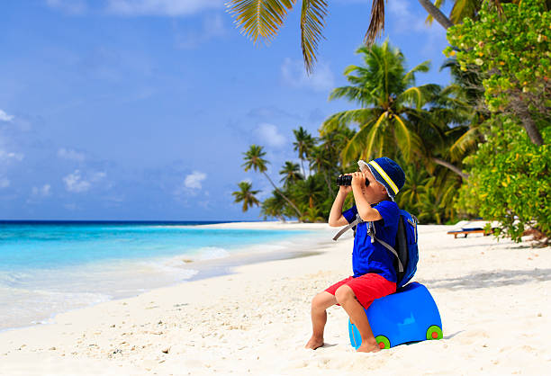 istock little boy travel on summer tropical beach with suitcase 485375676