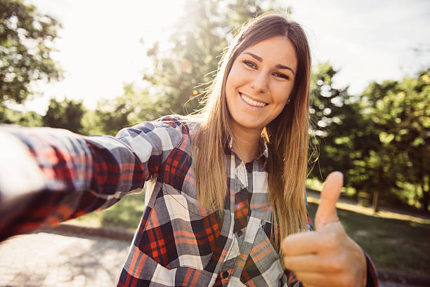 Giovane donna prendendo una selfie sul parco - foto stock