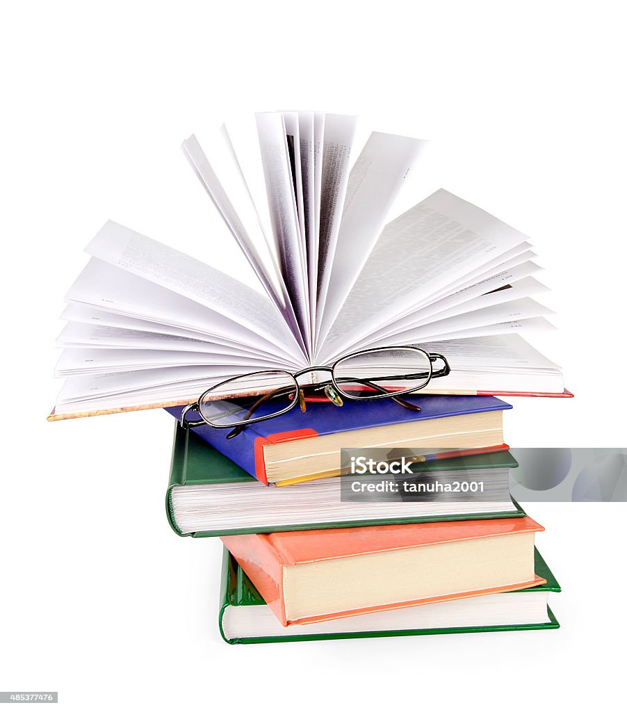 Opened books and glasses on table. Opened books and glasses on table isolated on white background. 2015 Stock Photo