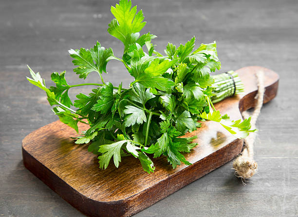 petersilie kulinarische kräuter auf einem schneiden holz-board - parsley stock-fotos und bilder