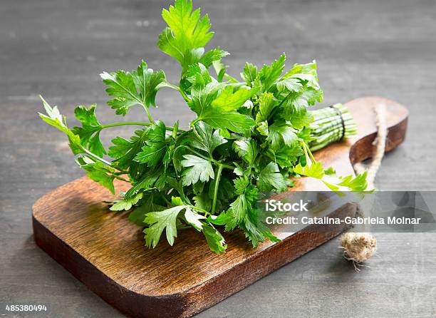 Parsley Culinary Herb On A Cutting Wooden Board Stock Photo - Download Image Now - Parsley, Spice, Condiment