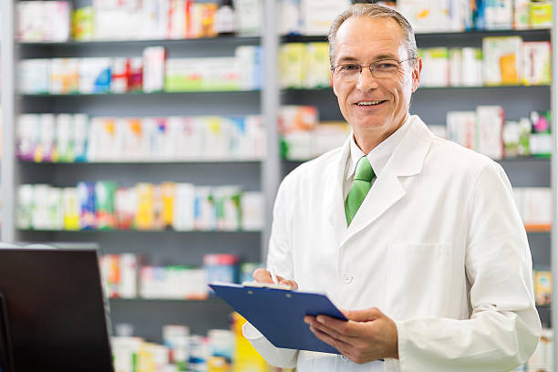 istock Smiling pharmacist writing medical chart and looking at camera. 485383526