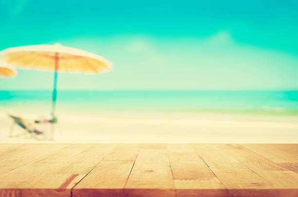 istock Wood table top on blurred beach background, vintage tone 485384256