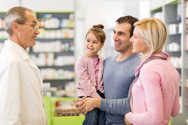 istock Smiling family at the pharmacy talking with pharmacist. 485393612