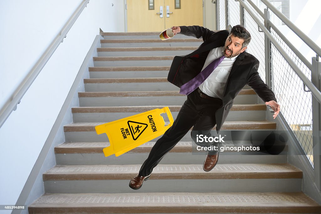 Hispanic Businessman Falling on stairs Mature Hispanic businessman falling down the stairs Falling Stock Photo
