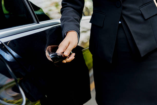 Chauffeur open car door Female chauffeur opening a luxury car door. door attendant photos stock pictures, royalty-free photos & images