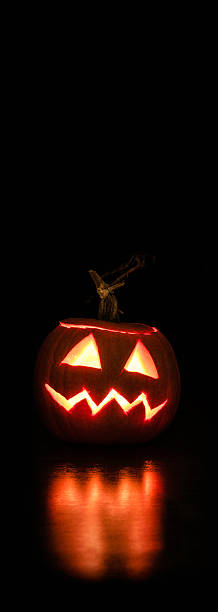 Halloween background with copy space and lit pumpkin