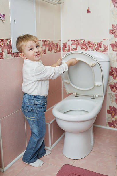 istock little boy looks in toilet 485403148