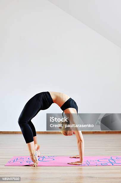 Mature Woman Exercising Yoga In Studio Stock Photo - Download Image Now - 2015, Active Lifestyle, Adult