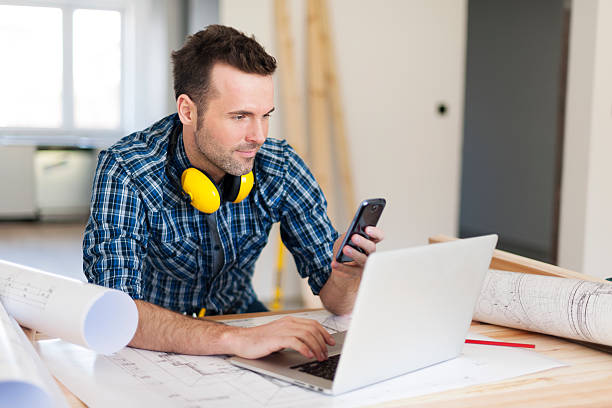 pracownik budowlany z urządzeń elektronicznych - computer construction using laptop construction site zdjęcia i obrazy z banku zdjęć