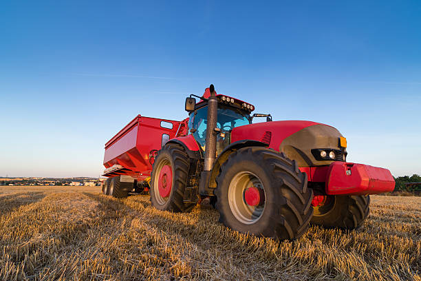 istock Agriculture tractor and trailer on a stubble field 485412518