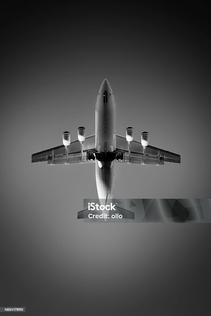 Landing airplane at dusk, view from directly below Landing airplane at dusk - black and white, view from directly below 2015 Stock Photo