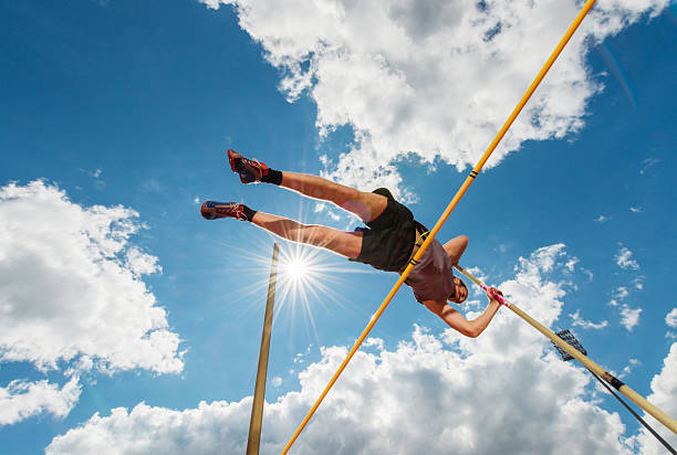 男性アスリート舞台走り高跳びアゲインストスカイます。 - high jump 写真 ストックフォトと画像