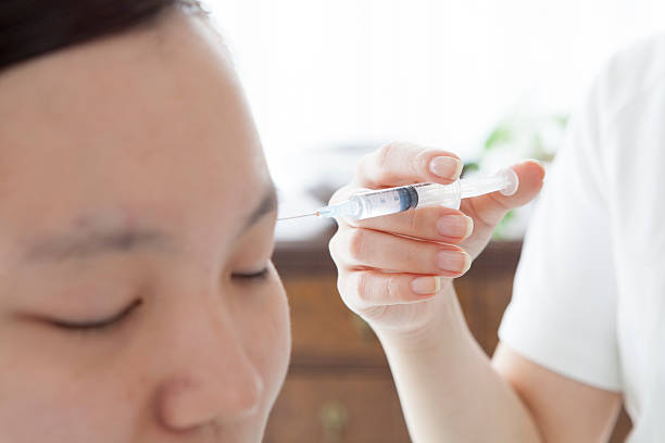 istock Adult woman having face injection 485423114