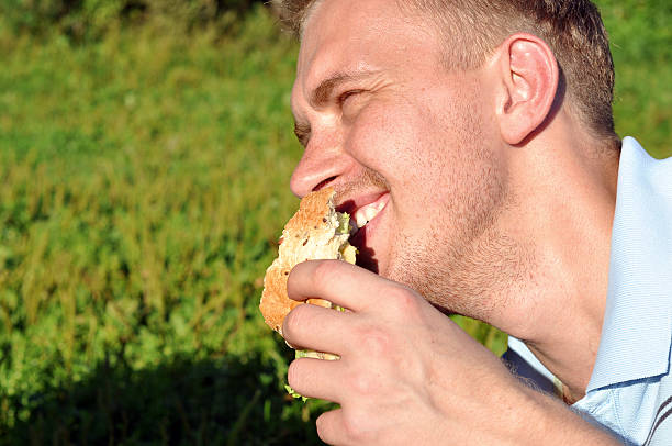 istock Young cheerful guy during family picnic 485425500