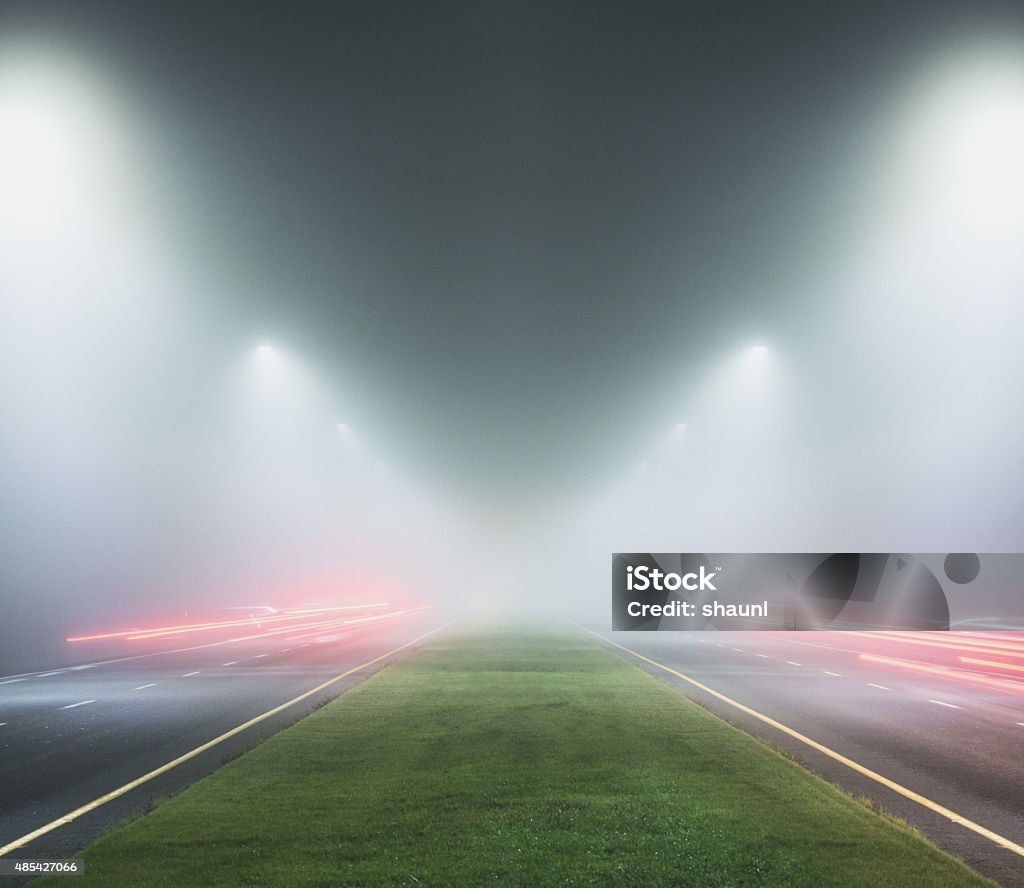 Wrong Turn in Fog A driver has made a wrong turn, travelling towards oncoming traffic in the lane at left.  Long exposure. 2015 Stock Photo