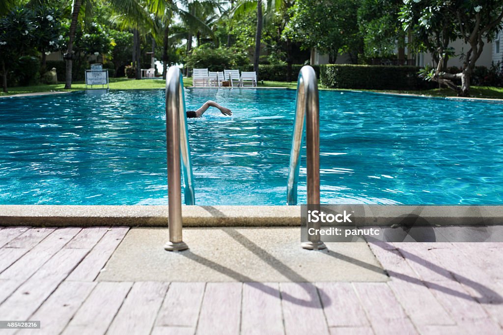 man is swimming in the swimming pool man is swimming in the swimming pool with stair and wooden deck 2015 Stock Photo