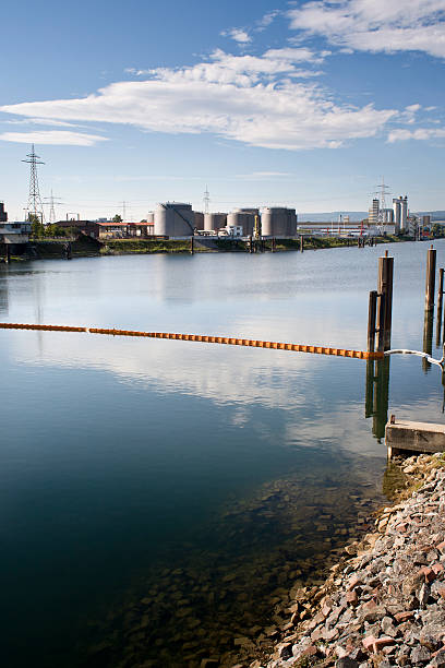 istock Oil barrier on the river, refinery 485428316