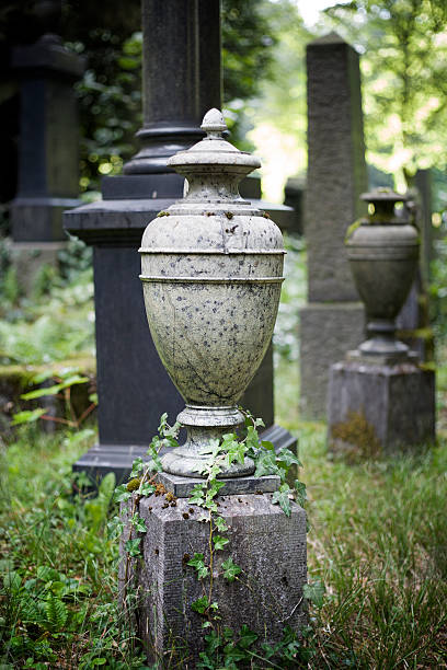 Old weathered urn or amphora made out of granite at the cemetery