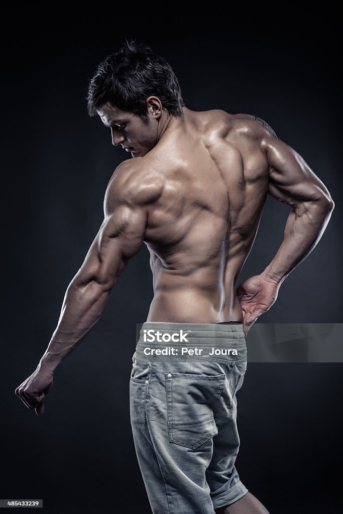Strong Athletic Man Fitness Model posing back muscles Strong Athletic Man Fitness Model posing back muscles, triceps, latissimus Abdominal Muscle Stock Photo