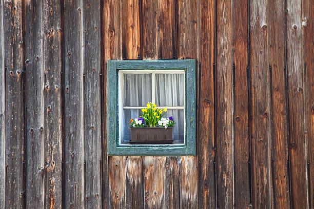 istock window of old wooden log house on wall background 485434962