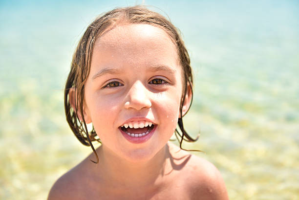 istock Girl on the beach is smiling and looking at camera. 485439600