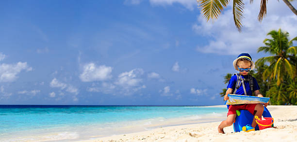 istock little boy travel on summer tropical beach with suitcase 485442070