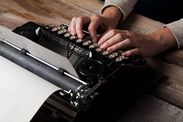 istock Hands writing on old typewriter over wooden background 485444626
