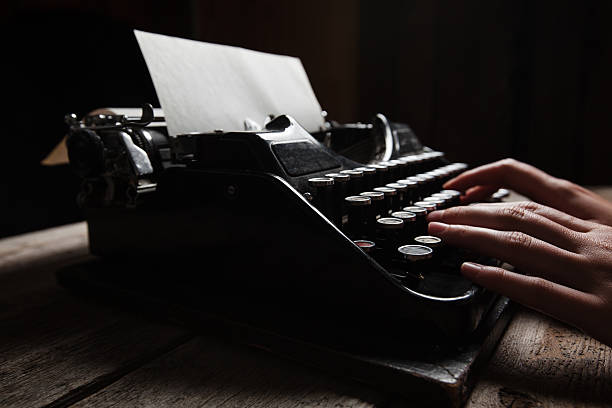 istock Hands writing on old typewriter over wooden background 485444910