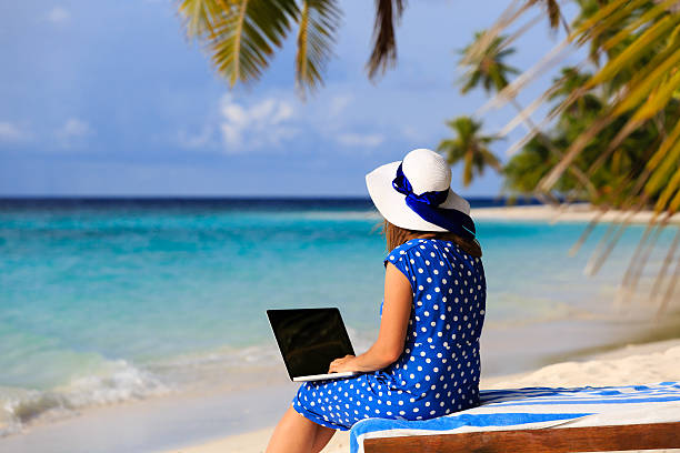 istock young woman with laptop on tropical vacation 485445012