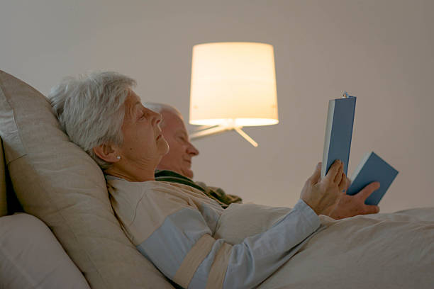 istock Senior couple reading a book in bed 485446247