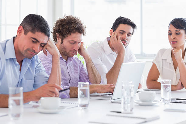 istock Woman watching sleepy executives at conference table 485448699