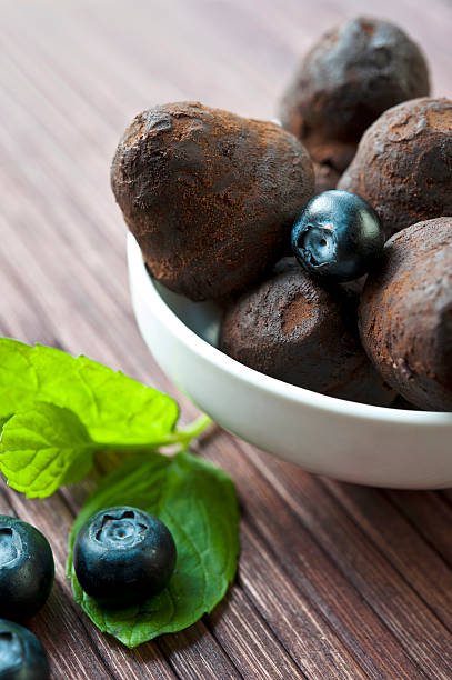 istock Chocolate truffles with blueberry and mint on wooden background 485449781