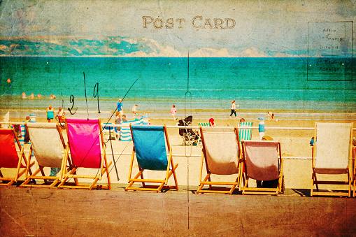 vintage style postcard with a beach scene, deckchairs standing in a row at the seaside promenade of Weymouth, England