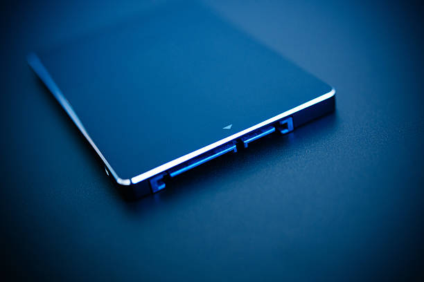Fast SSD disk SSD disk drive in blue technological background - tilt-shift lens used to accent the center of the hdd and to emphasize the attention its connections solid state disk photos stock pictures, royalty-free photos & images