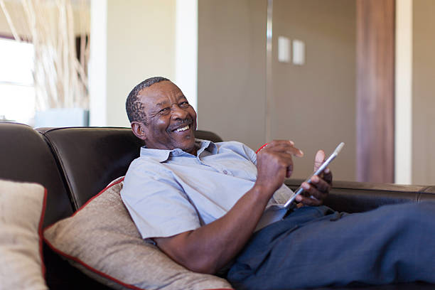 African male senior laughing at the game he's playing. stock photo