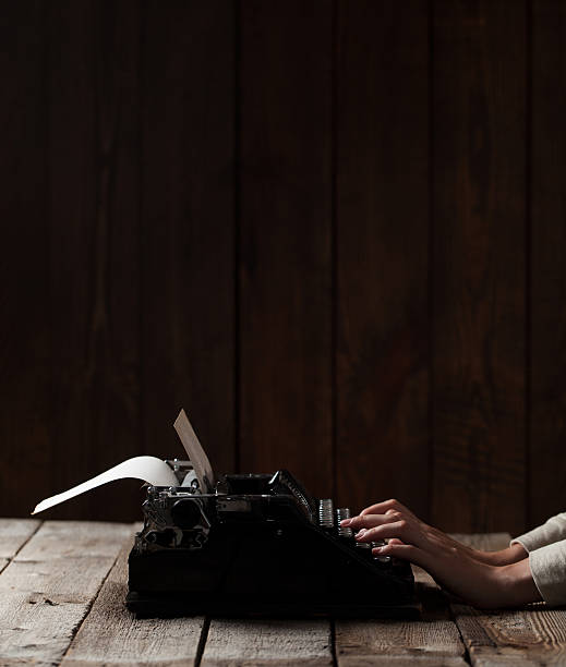 istock Hands writing on old typewriter over wooden background 485455506