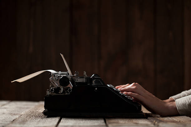 istock Hands writing on old typewriter over wooden background 485455522