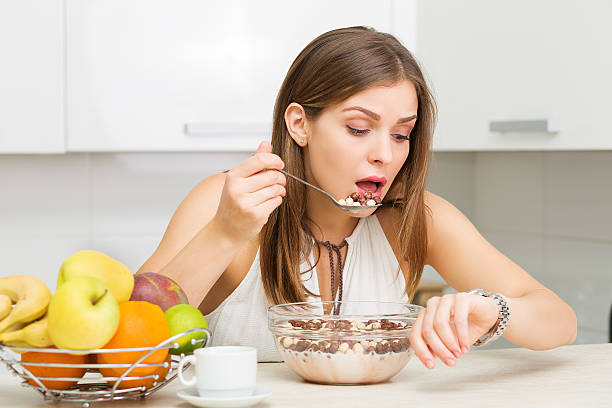 Healthy breakfast Beautiful woman having coffee, fruits and oatmeal for breakfast instant food stock pictures, royalty-free photos & images