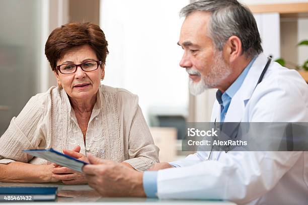 Doctor Talking To His Female Senior Patient Stock Photo - Download Image Now - Adults Only, Doctor, Patient