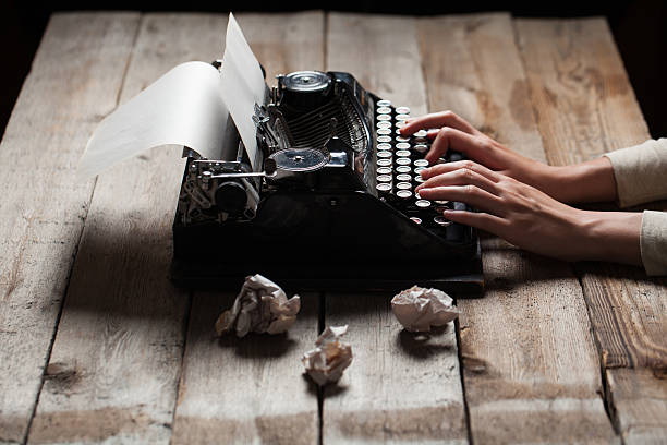 istock Hands writing on old typewriter over wooden background 485465208