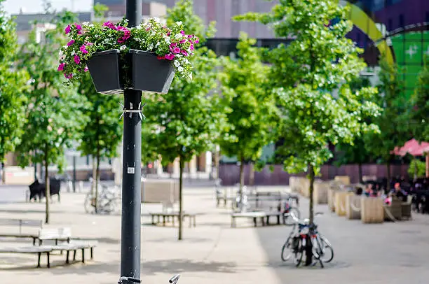 Street lamp decorated with fresh flowers in sunny spring day. Square near the St. Catherine Church. Eindhoven city center. Netherlands