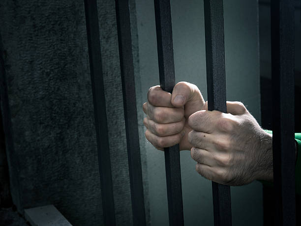 istock Man in jail hands close-up 485471302