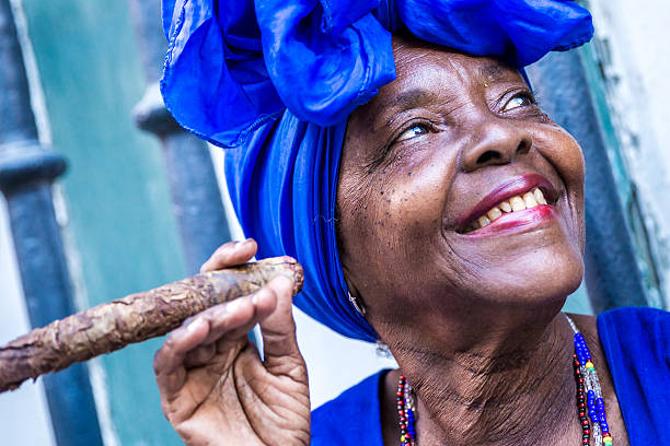 Portrait of african cuban woman smoking cigar in Havana, Cuba Portrait of african cuban woman smoking cigar in Havana, Cuba cuban ethnicity stock pictures, royalty-free photos & images