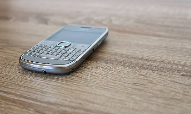 Silver mobile phone on the wooden table stock photo