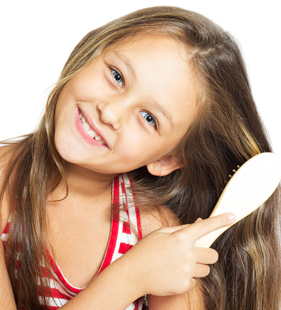 pretty smiling little girl brushing her hair isolated on white background