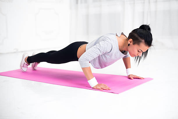istock Young latin woman warming up and doing push ups at 485473524