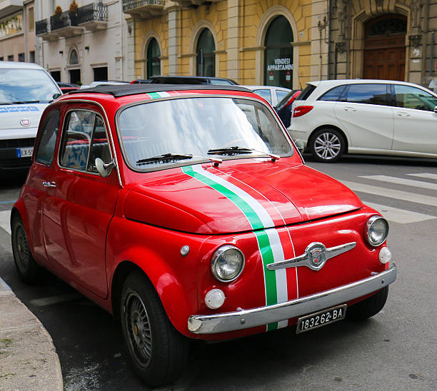 Fiat 500 in Bari, Italy Bari, Italy - March 16, 2015: Unidentified people near a red version of the iconic Fiat 500 with the Italian flag in the center of Bari, Italy. little fiat car stock pictures, royalty-free photos & images