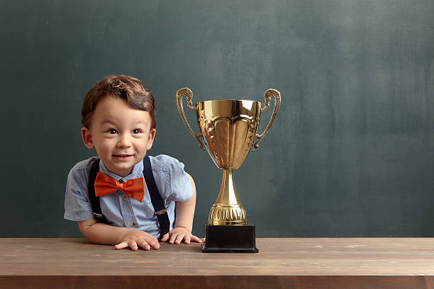 istock Little boy smiling with a golden trophy 485474980